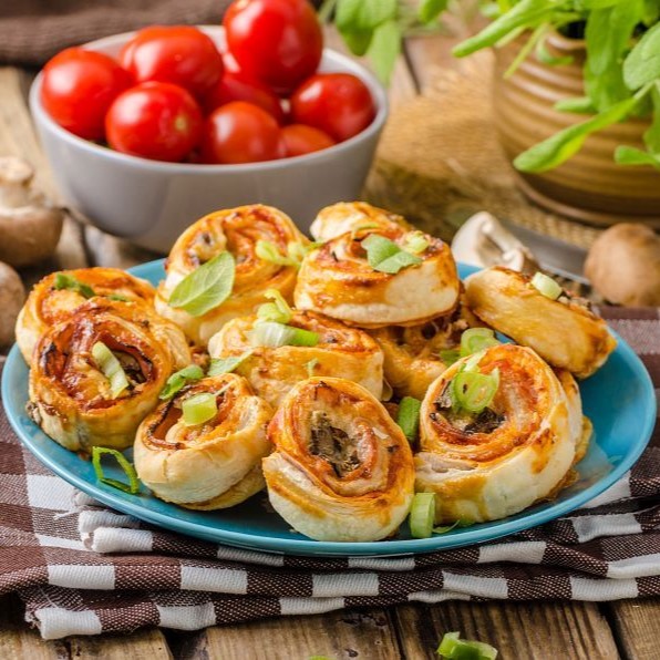 Pizza snails in puff pastry with ham, cheese and mushrooms