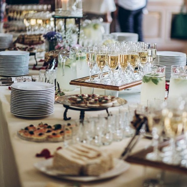 Stylish champagne glasses and food  appetizers on table at wedding reception