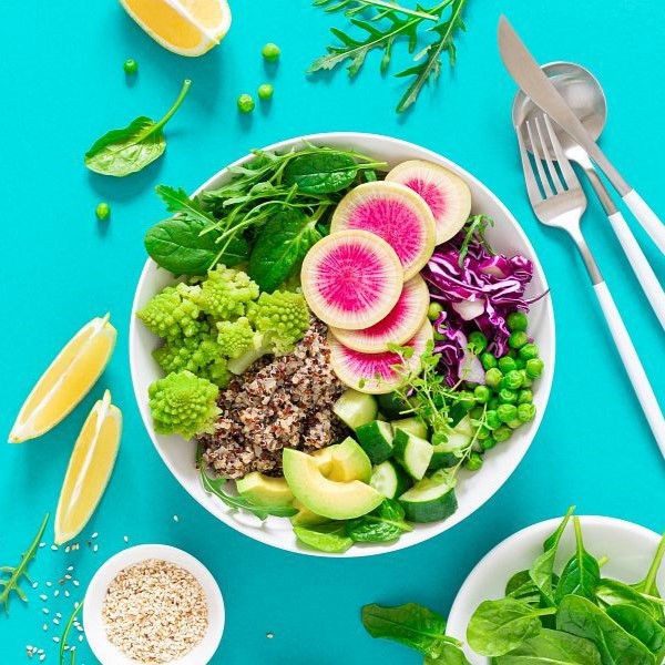 Vegan lunch bowl with quinoa, cucumber, green peas, radish, romanesco and red cabbage, avocado, spinach and arugula salad, healthy eating, vegetarian food concept, veggie detox and antioxidant diet