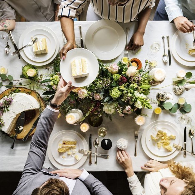 Wedding party sharing a cake at a table